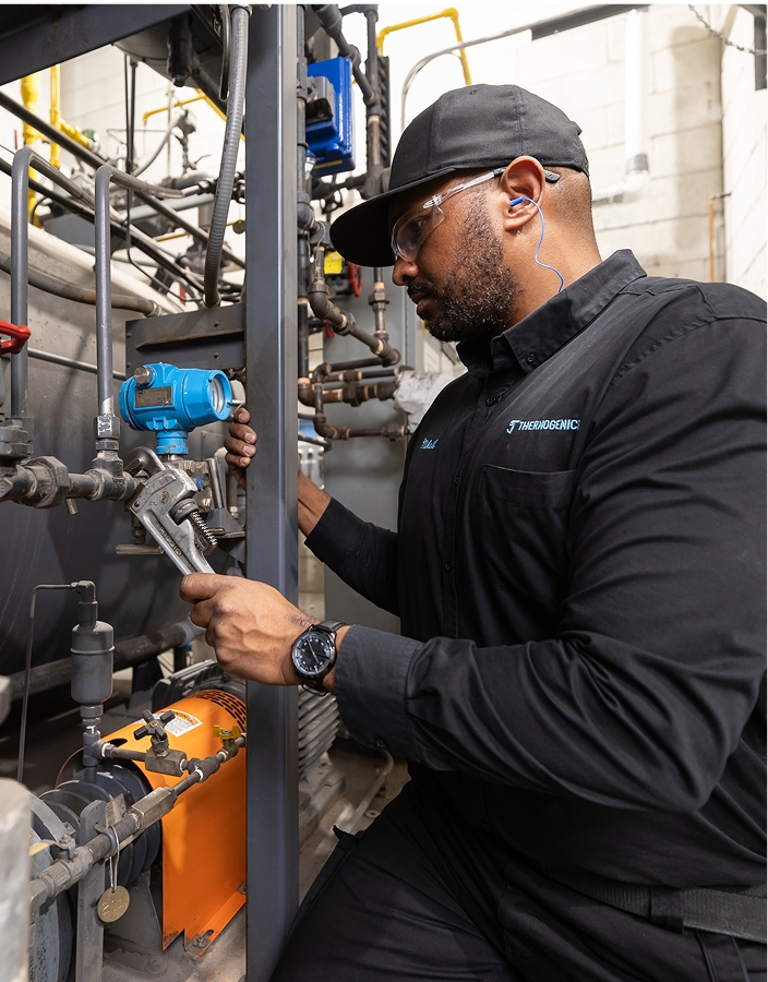 Thermogenics technician with wrench fixing boiler